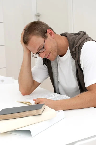 Usmívající se muž student čtení — Stock fotografie