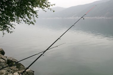 Fishing rods over the water clipart