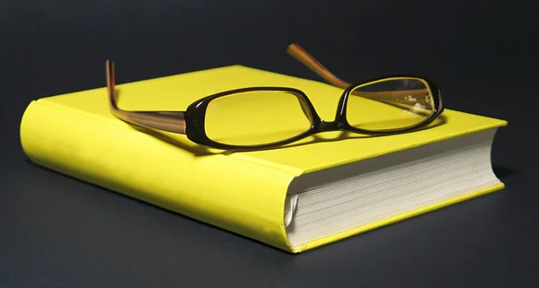Sarı kitap gözlük — Stok fotoğraf
