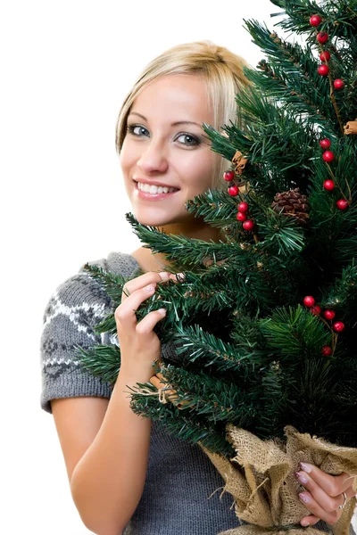 Niedliche Frau lächelt und hält einen Weihnachtsbaum — Stockfoto
