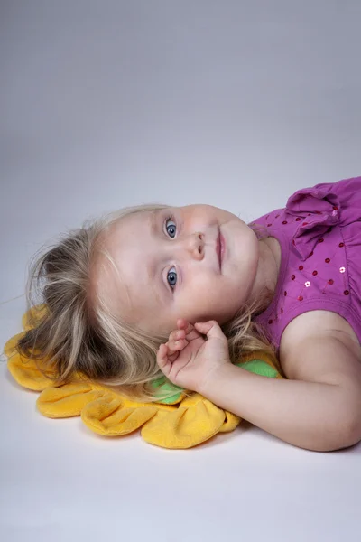 Девушка на жёлтой подушке — стоковое фото