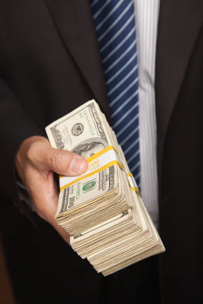 Man stapel geld overhandigen — Stockfoto