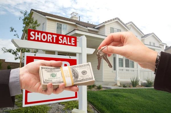 家の鍵と短い販売のための現金を引き渡す — ストック写真