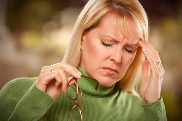 Grimaserande kvinna som lider av en huvudvärk — Stockfoto
