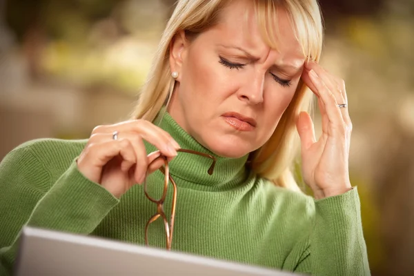Grijnzende vrouw lijden een hoofdpijn — Stockfoto