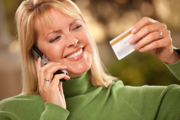 Mulher com cartão de crédito e telefone — Fotografia de Stock