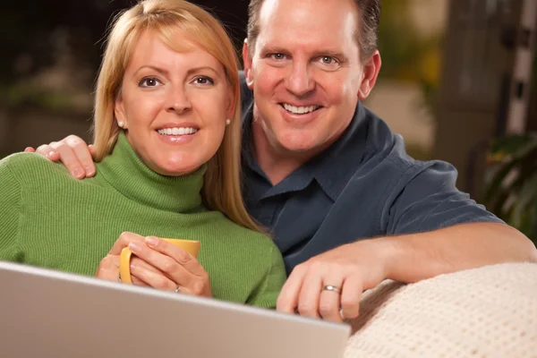 ハンサムなの幸せなカップルが彼らのラップトップを使用して — ストック写真
