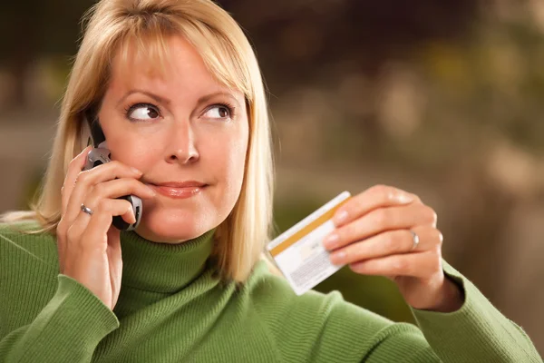 Γυναίκα χρησιμοποιώντας το τηλέφωνο και την πιστωτική κάρτα — Φωτογραφία Αρχείου