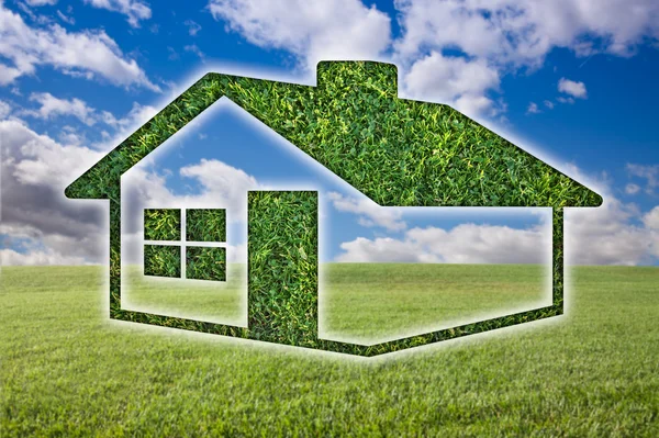 Зелена трава будинок значок над полем, Синє небо — стокове фото