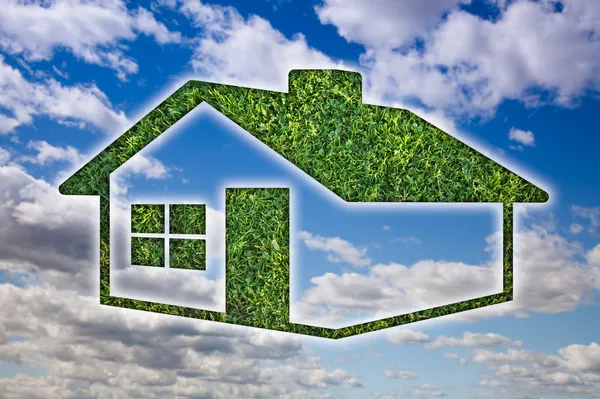 Yeşil çim ev simgesinin üzerine mavi gökyüzü — Stok fotoğraf