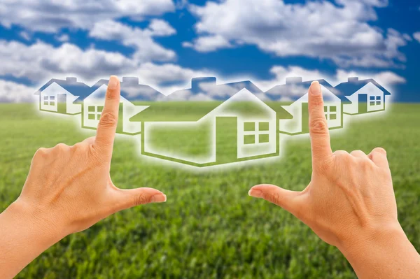 Hands Framing Houses Over Grass Field — Stock Photo, Image