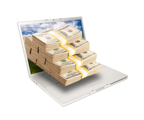 Laptop com pilha de dinheiro através da tela — Fotografia de Stock