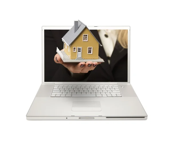 Mujer entregando la casa a través de la pantalla del ordenador portátil —  Fotos de Stock