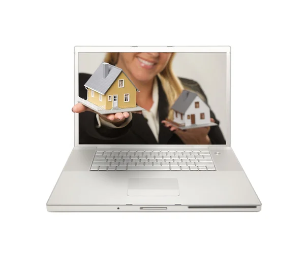 Donna con casa attraverso lo schermo del computer portatile Immagini Stock Royalty Free