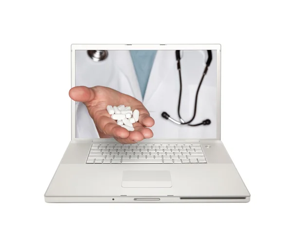 Médico entrega comprimidos através da tela do laptop — Fotografia de Stock
