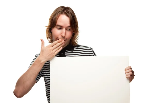 Zábava mladý muž s rukou ústa drží prázdné bílé ceduli izolovaných na w — Stock fotografie