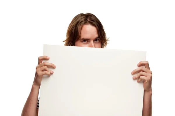 Divertente giovane uomo che tiene vuoto segno bianco isolato su uno sfondo bianco . — Foto Stock