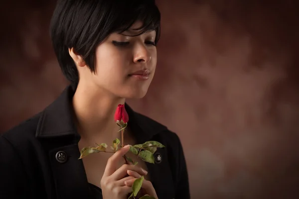 Αρκετά πολυεθνική νεαρή ενήλικη γυναίκα, κρατώντας ένα ενιαίο τριαντάφυλλο πορτρέτο με se — Φωτογραφία Αρχείου