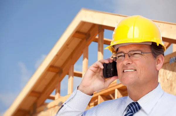 Male Contractor in Hardhat at Construction Site Talks on Cell Phone. Stock Photo