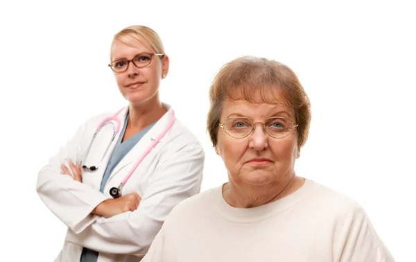 Mujer mayor preocupada con el doctor detrás aislado sobre un fondo blanco . — Foto de Stock