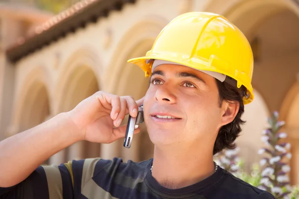Knappe hispanic contractant met harde hoed spreken op zijn mobiele telefoon. — Stockfoto