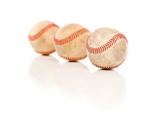 Três bolas de beisebol isoladas em um fundo branco reflexivo . — Fotografia de Stock