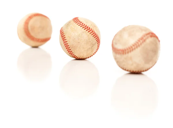 Trois balles de baseball isolées sur un fond blanc réfléchissant . — Photo