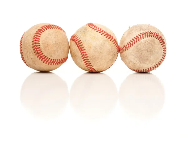Trois balles de baseball isolées sur un fond blanc réfléchissant . — Photo