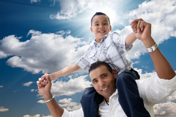 Padre e hijo hispanos se divierten sobre nubes — Foto de Stock