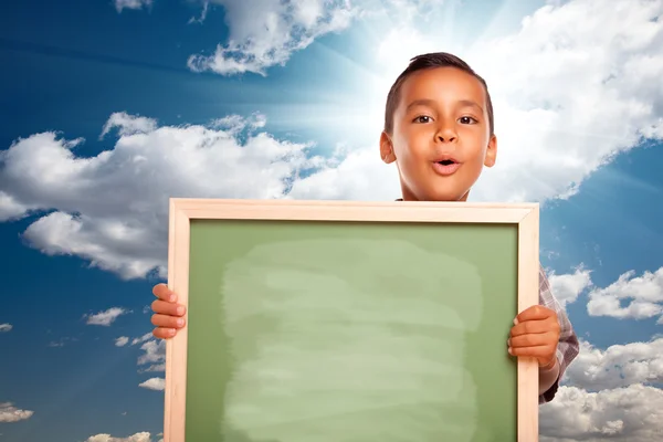Orgulhoso hispânico menino segurando branco quadro sobre céu — Fotografia de Stock