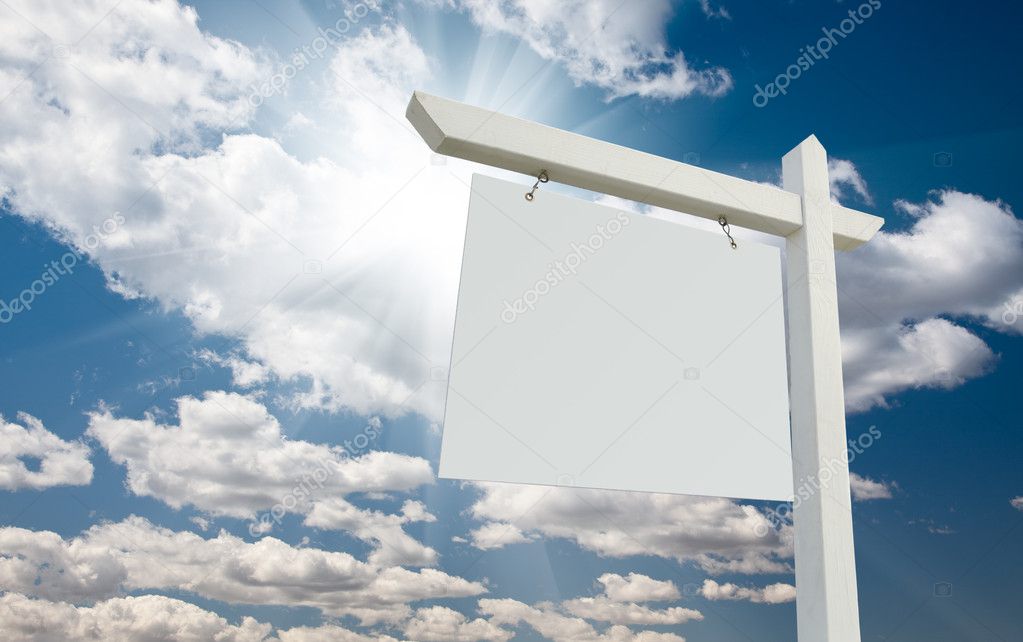 Blank Real Estate Sign over Clouds and Blue Sky