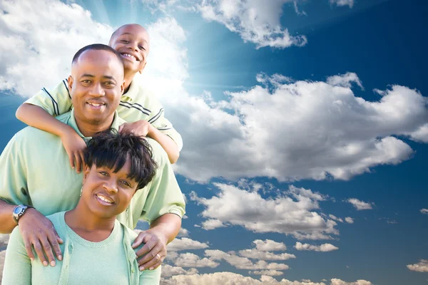 幸福的非洲裔美国家庭在蓝蓝的天空和云 — 图库照片