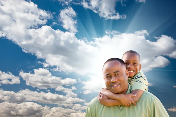 Szczęśliwy człowiek african american z dzieckiem nad chmury i niebo — Zdjęcie stockowe