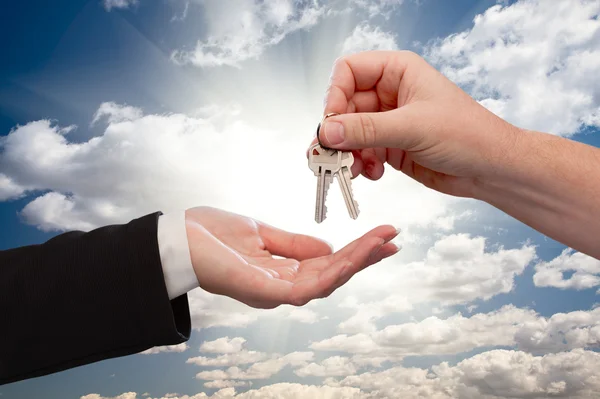 stock image Male Handing Keys to Female Over Clouds and Rays