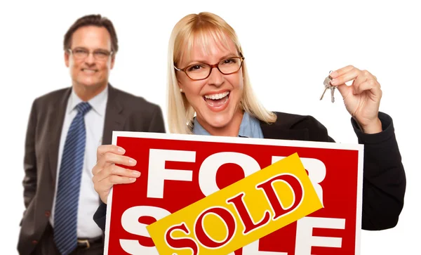 Mann mit blonder Frau hält Schlüssel in der Hand und verkauft Verkaufsschild — Stockfoto