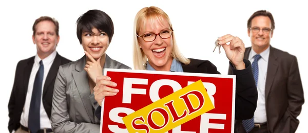 Immobilien-Team mit Frau, die Schlüssel hält und zum Verkauf verkauft Zeichen — Stockfoto