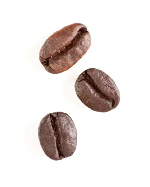 Три жареных кофейных зерен на белом — стоковое фото