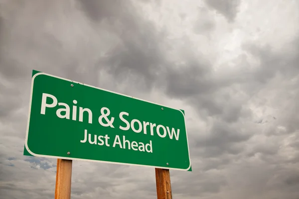 Ból i smutek znak drogowy zielony ponad chmury — Zdjęcie stockowe