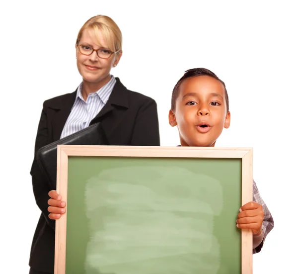 Ispanico ragazzo holding gesso bordo e femmina insegnante dietro — Foto Stock