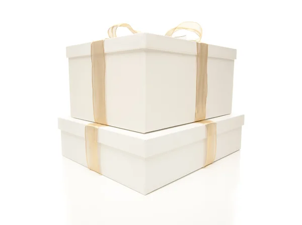 Skládané bílé dárkové krabičky zlatou stužkou, samostatný — Stock fotografie