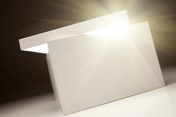 Біла коробка з кришкою відкриває щось дуже яскраве — стокове фото
