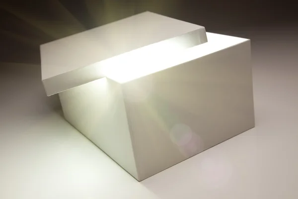 Bílý box s víkem odhalí něco velmi světlé — Stock fotografie