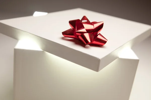 Tampa da caixa de presente do arco vermelho mostrando conteúdo muito brilhante — Fotografia de Stock