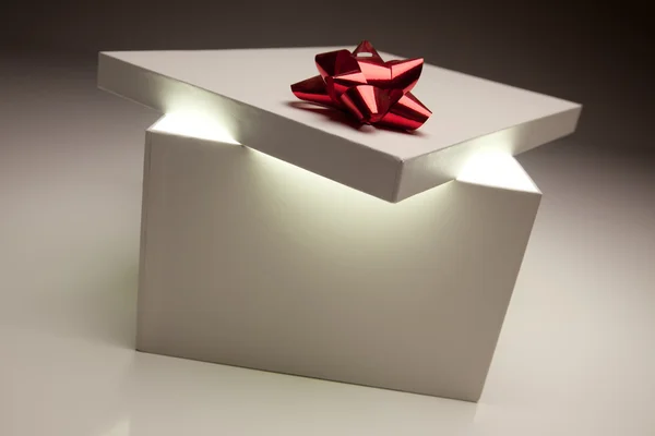 Couvercle de boîte cadeau arc rouge montrant contenu très lumineux — Photo
