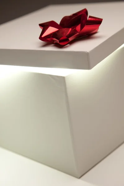 Couvercle de boîte cadeau arc rouge montrant contenu très lumineux — Photo