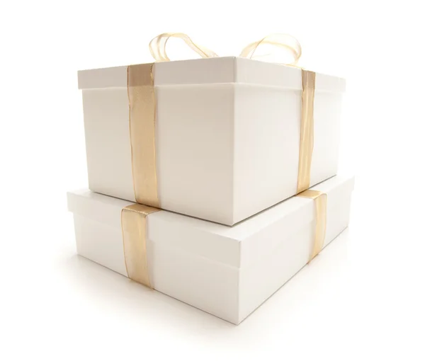 Boîtes cadeaux empilées blanches avec ruban d'or isolé — Photo