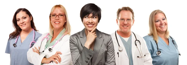 Молода багатоетнічна жінка з лікарями та медсестрами позаду — стокове фото