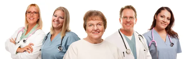 Femme âgée souriante avec des médecins et des infirmières médicales derrière — Photo