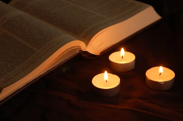 stock image Lit candles and opened Bible