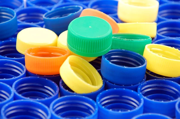 Reihen blauer und bunter Plastikdeckel — Stockfoto